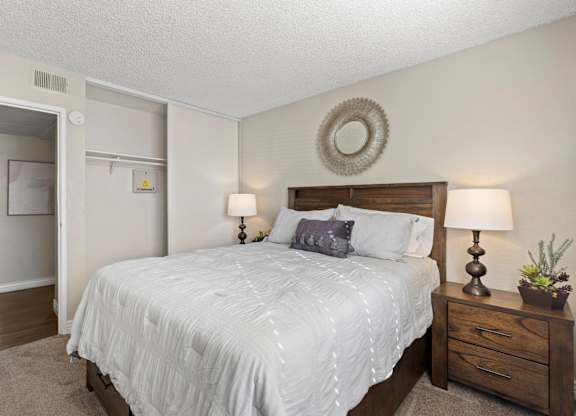 A bedroom with a bed, nightstand, and lamp.