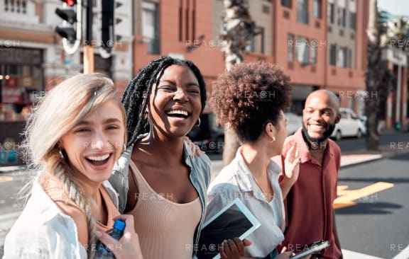 a group of young women and men standing on a city street