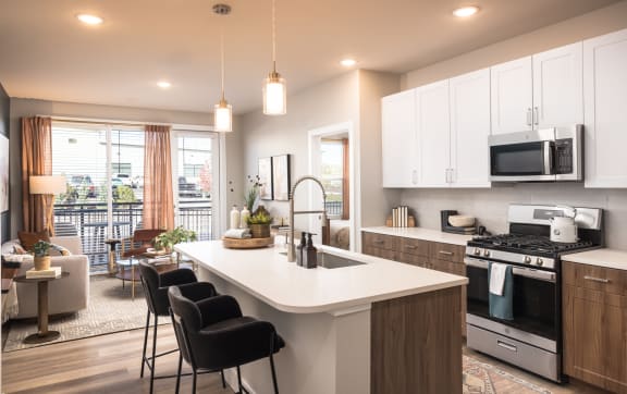 an open kitchen and living room with a large white counter top