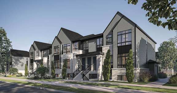 a development of townhouses on a street with trees