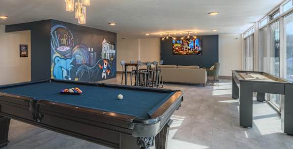 interior photo of clubhouse amenities showing a Pool table & TV