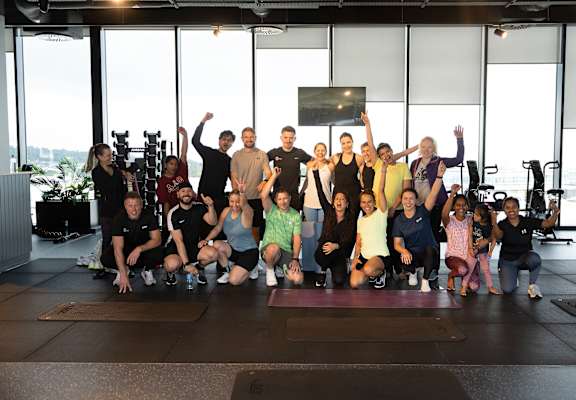A group of people are posing for a photo in a gym.