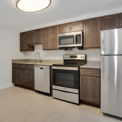 a kitchen with wooden cabinets and stainless steel appliances
