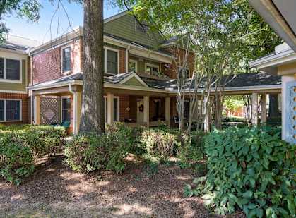 the front yard of a house with trees and bushes