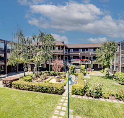 a view of the courtyard of a building with grass and trees