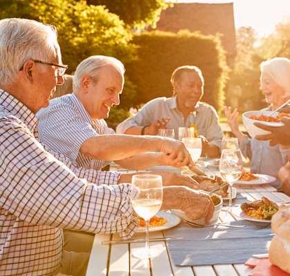 A group of people having a meal together outdoors.