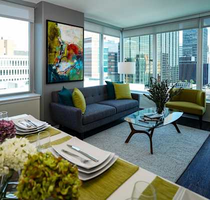 a living room with a couch and a table and a large window  at Two Twelve Clayton, Clayton, MO, 63105