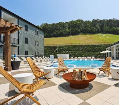 A large outdoor patio with a pool and chairs. at Arcadia Cartersville Apartments, Georgia