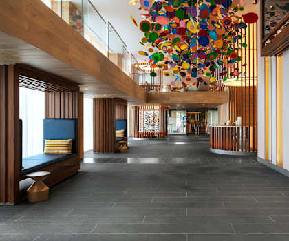 the lobby of a hotel with a large colorful chandelier