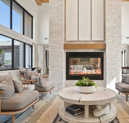 a living room with couches and a coffee table in front of a fireplace