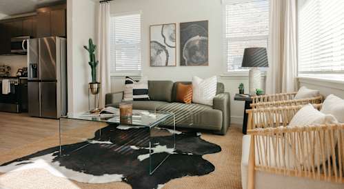 A living room with a large painting on the wall and a wooden cabinet.