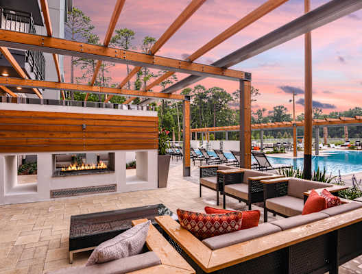 A wooden patio with a fireplace and seating area. at JTB Apartments, Jacksonville, FL, 32256