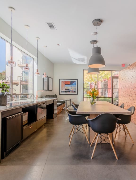 a dining area with a wooden table and chairs and a large brick wall with a flat screen