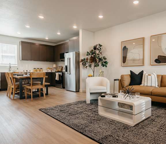 A modern living room with a white sofa and a coffee table in the center.