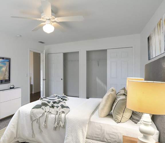 a bedroom with a large bed and a ceiling fan