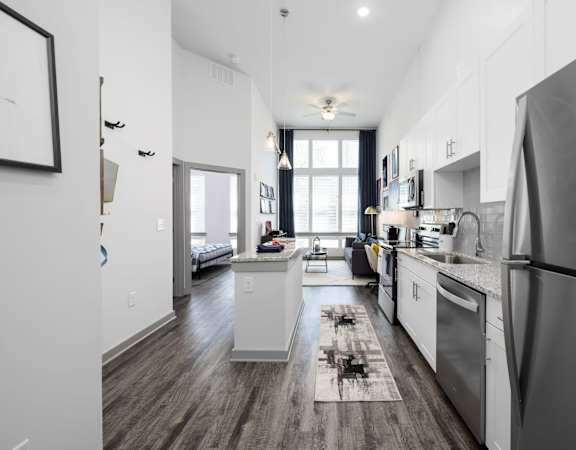 A modern kitchen with stainless steel appliances and wooden floors.