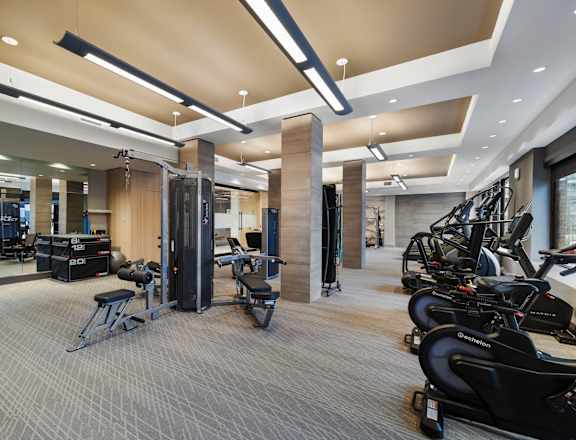 a gym with weights machines and other equipment in a large room