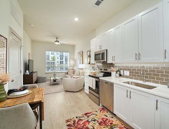 A kitchen with white cabinets and a tiled backsplash.