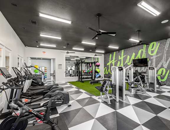 a spacious fitness center with a checkered floor and a large mural on the wall