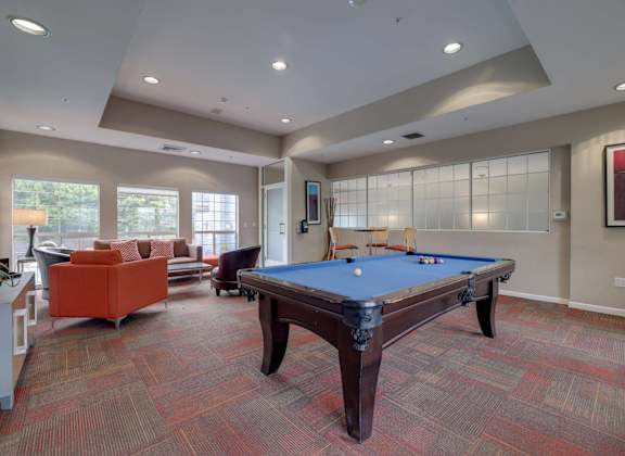 A room with a pool table and a couch.