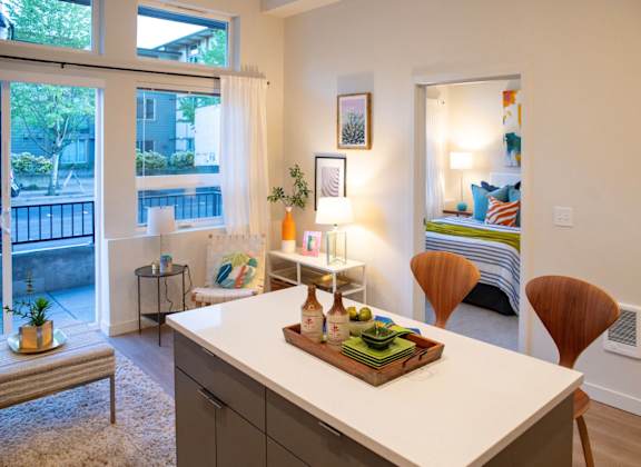 an open kitchen and living room with a view of a bedroom