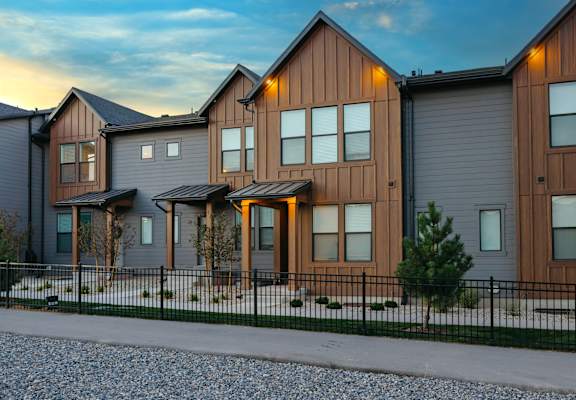 A row of modern houses with brown and grey exteriors.