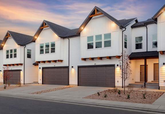 A row of modern houses with garages and driveways.