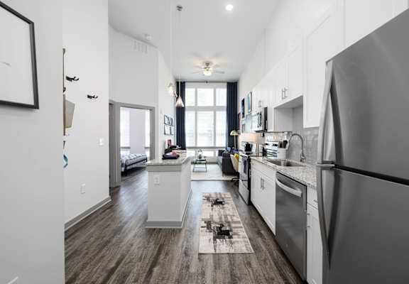A modern kitchen with stainless steel appliances and wooden floors.