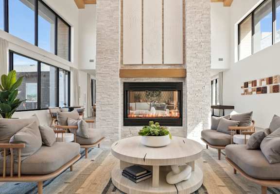 a living room with couches and a coffee table in front of a fireplace