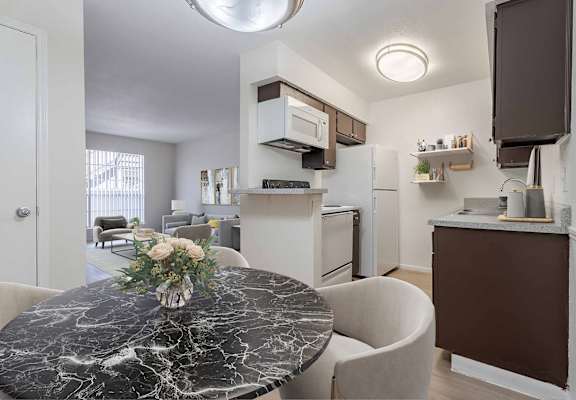 A kitchen with a marble table and a fridge.