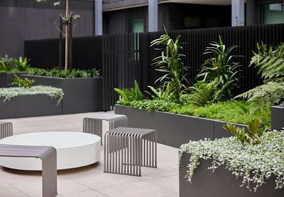 An outdoor seating area with tables and plants