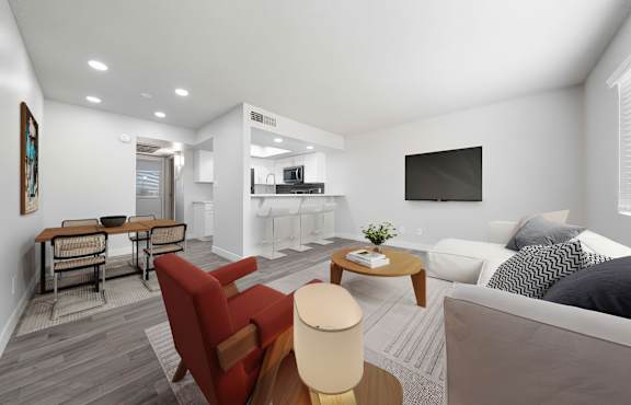 A modern living room with a grey couch, a red chair, and a wooden coffee table.