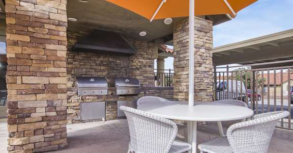 Patio with a table and chairs and a barbecue grill