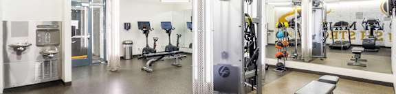 A gym with a variety of equipment including weights and cardio machines.