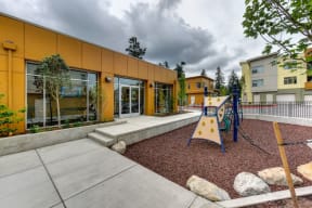 Outdoor Playground with Jungle Gym, Wood Chip Floor, Rocks and Building Exterior