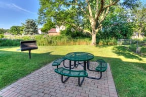 courtyard BBQ area with a green picnic table