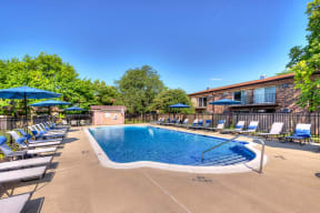 outdoor swimming pool surrounded by lounge chairs at Eagle Creek Apartments in Westmont, IL