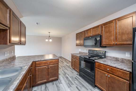 A kitchen with wooden cabinets and a black stove top oven.