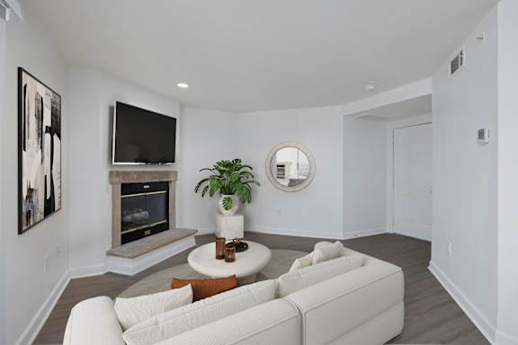 A living room with a white couch and a fireplace.