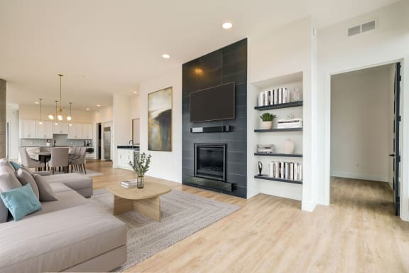 a living room with white walls and hardwood floors