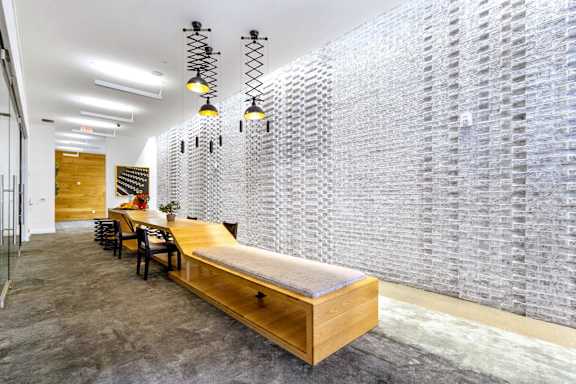 A long hallway with a bench and a wall of windows.