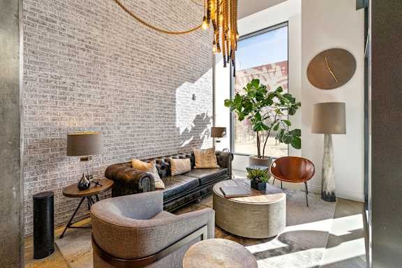 A living room with a grey couch, a round table, and a plant.