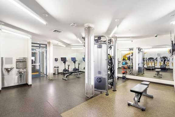 A gym with a variety of equipment including weights and cardio machines.