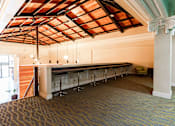 Thumbnail 6 of 8 - A room with a bar and stools.