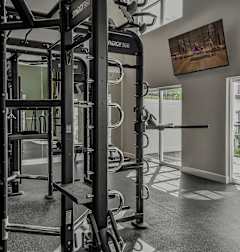 A gym with a punching bag, weights, and exercise equipment.