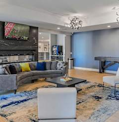 A modern living room with a grey sofa and a television mounted above the fireplace.