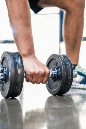two people are holding dumbbells in a gym