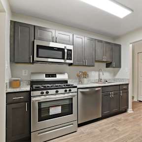 A kitchen with black cabinets and stainless steel appliances.
