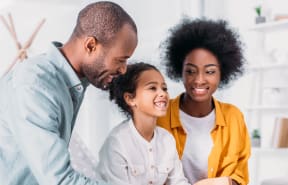 happy family sitting at the table in the living room stock photo #