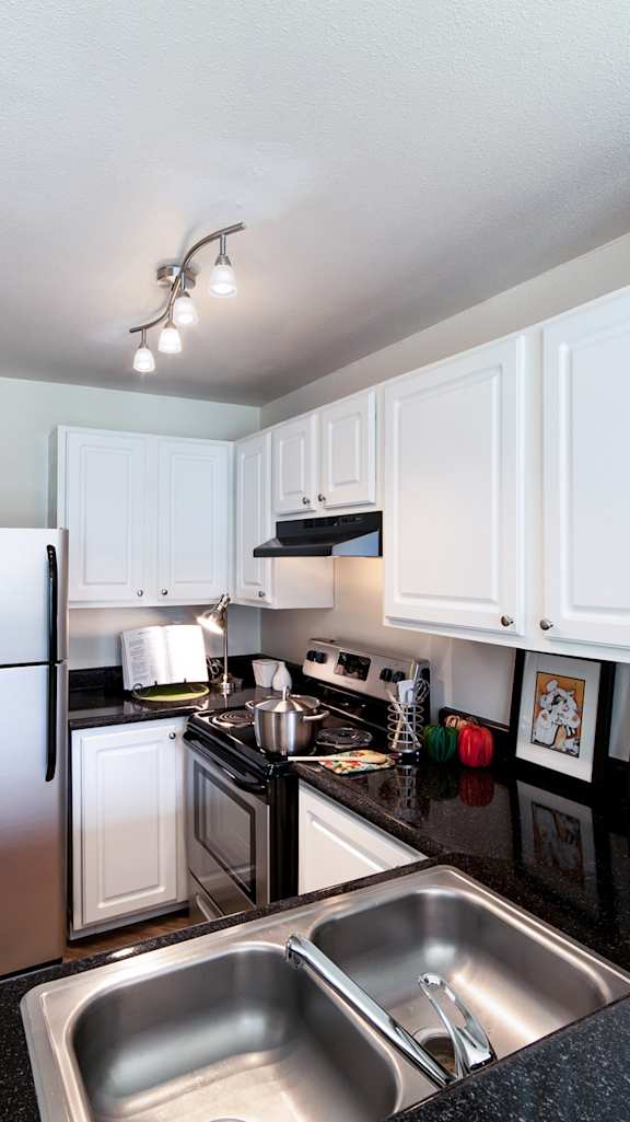 a kitchen with white cabinets and stainless steel appliances